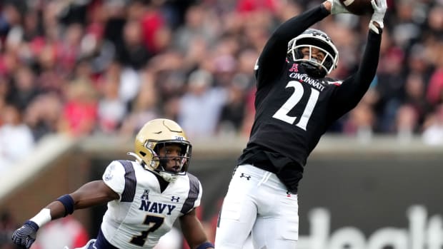 Cincinnati Bearcats wide receiver Tyler Scott (21) completes a catch as Navy Midshipmen cornerback Mbiti Williams Jr. (7) defends in the first quarter during a college football game, Saturday, Nov. 5, 2022, at Nippert Stadium in Cincinnati. Ncaaf Navy Midshipmen At Cincinnati Bearcats Nov 6 0143